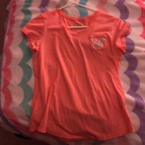 A orange shirt with a butterfly at the top.